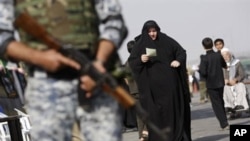 An Iraqi soldier stands guard as Muslim Shiite pilgrims pass through Baghdad on their way to the holy city of Karbala to mark the Shiite mourning day of Arbaeen, 01 Feb 2010