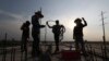 Workers are silhouetted at the construction site of a bridge in Krasang Chrum village on the outskirts of Phnom Penh, Cambodia, Thursday, May 14, 2020. (AP Photo/Heng Sinith)