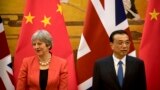 British Prime Minister Theresa May, left, and Chinese Premier Li Keqiang attend a signing ceremony at the Great Hall of the People in Beijing, Wednesday, Jan. 31, 2018. 