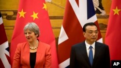 PM Inggris Theresa May (kiri) dan PM China Li Keqiang menghadiri upacara penandatanganan kerjasama di Balai Rakyat China di Beijing, Rabu, 31 Januari 2018. 