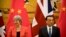 British Prime Minister Theresa May, left, and Chinese Premier Li Keqiang attend a signing ceremony at the Great Hall of the People in Beijing, Wednesday, Jan. 31, 2018.
