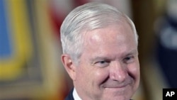 Defense Secretary Robert Gates waits for the start of a ceremony in the East Room of the White House in Washington, May 2, 2011