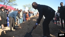 El presidente de Botswana, Duma Boko, arroja arena sobre la tumba durante el entierro y el servicio conmemorativo del difunto Pitseng Gaoberekwe en la aldea de Metsiamanong, Reserva de Caza del Kalahari Central (CKGR), el 10 de diciembre de 2024.