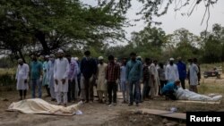 Warga Muslim India melakukan shalat jenazah korban COVID-19 sebelum dimakamkan di New Delhi (foto: Reuters). 