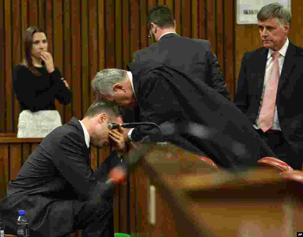 A crying Oscar Pistorius, left, is comforted by his defense lawyer, Barry Roux, during the third day of sentencing hearings in the high court in Pretoria, South Africa.