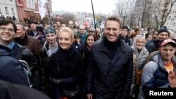 ARCHIVO - El líder de la oposición rusa Alexei Navalny y su esposa Yulia caminan durante una manifestación de la oposición en Moscú, el 27 de octubre de 2013.