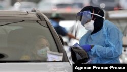  A health worker conducts a COVID-19 test at the St. Vincent's Bondi Beach COVID-19 drive through testing clinic on Dec. 22, 2021, in Sydney. 