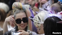 Singer Lady Gaga poses for a photograph with a fan upon her arrival at Narita international airport in Narita, east of Tokyo May 8, 2012. 