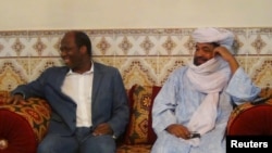 FILE - Iyad Ag Ghaly, right, the alleged leader of the extremist Ansar Dine Islamist group, meets Burkina Faso's then-foreign minister, Djibril Bassole, in Kidal, Mali, in 2012. The International Criminal Court on June 21, 2024, made public an arrest warrant for Ghaly.
