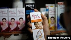 A customer picks up a 'Fair & Lovely' brand of skin-lightening product from a shelf in a shop in Ahmedabad, India, June 25, 2020.