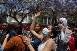 FILE - Anti-government protesters wearing masks to help protect themselves from the coronavirus shout slogans during ongoing protests against the Lebanese government outside the military court in Beirut, Lebanon, May 7, 2020.