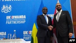 FILE — Britain's Home Secretary James Cleverly and Rwanda's Foreign Minister Vincent Biruta shake hands after signing a new treaty, in Kigali, Dec. 5, 2023. 