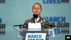 FILE - Emma Gonzalez, a survivor of the mass shooting at Marjory Stoneman Douglas High School in Parkland, Fla., stands silently for the amount of time it took the shooter to go on a killing spree, during a rally in support of gun control in Washington, Mar. 24, 2018.