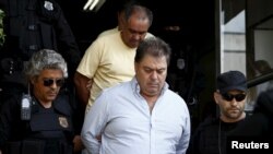 FILE - Former senator Gim Argello is escorted by federal police officers as he leaves the Institute of Forensic Science in Curitiba, Brazil, April 13, 2016.