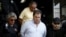 FILE - Former senator Gim Argello is escorted by federal police officers as he leaves the Institute of Forensic Science in Curitiba, Brazil, April 13, 2016.