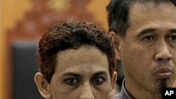 Indonesian militant Umar Patek, center, accompanied by his lawyer Ashludin Hatjani, right, speaks to the press during his trial at West Jakarta District Court in Jakarta, Indonesia, May 7, 2012. 