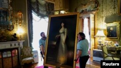 Workers carry "The Marquise of Lazan" painting by the Spanish painter Francisco Goya at Liria Palace in Madrid, Spain, Sept. 9, 2019. 