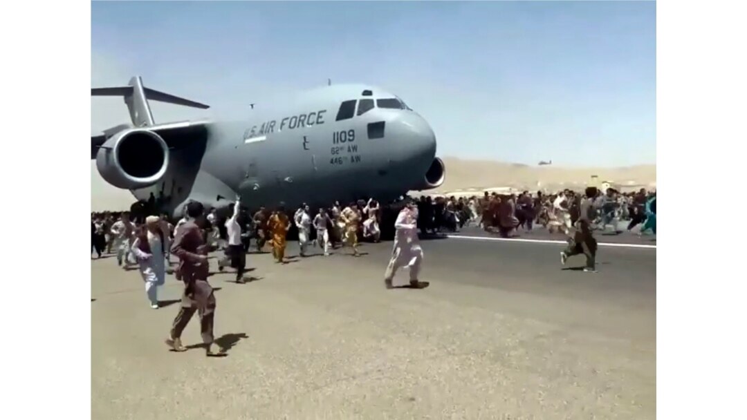 Hundreds of people run alongside a U.S. Air Force C-17 transport plane as it moves down a runway of the international airport, in Kabul, Afghanistan, Aug.16. 2021. (Verified UGC via AP)