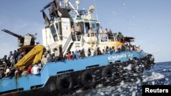 Des migrants somaliens, soudanais et éthiopiens, transportés à bord d’un bateau de l’armée libyenne après avoir été secourus près de la côte de Misrata, Libye, 3 mai 2015. 