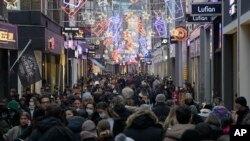 Crowds of people walk down a street on the last Saturday before Christmas in Amsterdam, the Netherlands, Dec. 18, 2021. 