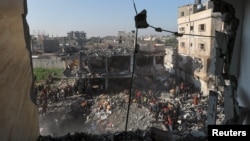 Palestinians gather at the site of an Israeli strike on a house in Rafah, in the southern Gaza Strip, Dec. 19, 2023.