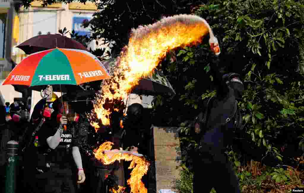 An anti-government demonstrator throws a petrol bomb towards Tsim Sha Tsui Police Station during a protest in Hong Kong, China.