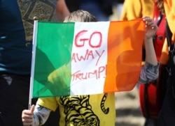 FILE - A demonstrator protests before the arrival of U.S President Trump at Shannon Airport in the west of Ireland, Wednesday, June 5, 2019.