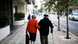 FILE - A couple walk on a sidewalk in Santiago, Chile, Wednesday on May 3, 2017. 