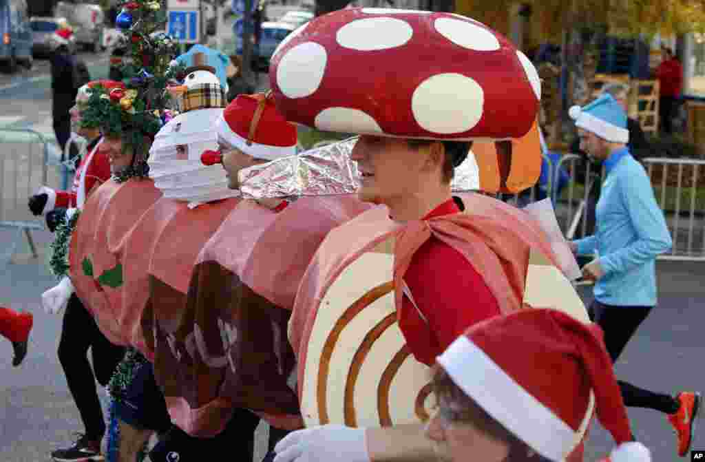 Atletas vestidos de Pai Natal e outras indumentárias de Natal para a 37&ordf; Corrida de Natal nas ruas de Issy Les Moulineaux, nos arredores de Paris. Dez. 15, 2013.