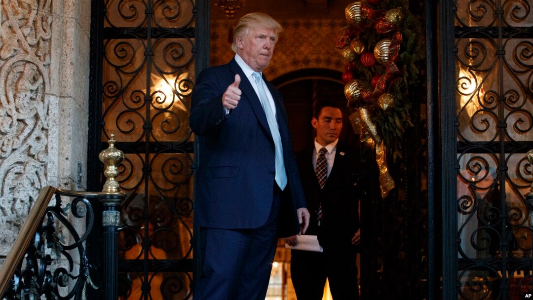 Presiden AS terpilih Donald Trump mengacungkan jempol setelah berbicara dengan wartawan di Mar-a-Lago, di Palm Beach, Florida (28/12). (AP/Evan Vucci)