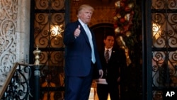 Presiden AS terpilih Donald Trump mengacungkan jempol setelah berbicara dengan wartawan di Mar-a-Lago, di Palm Beach, Florida (28/12). (AP/Evan Vucci)