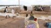 Displaced Sudanese children are seen by their temporary shelters on the side of a road in the town of Osaylat, 60 kilometers southeast of the capital in Khartoum, Sudan, Aug. 7, 2020. 