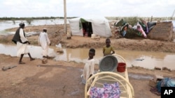 Displaced Sudanese children are seen by their temporary shelters on the side of a road in the town of Osaylat, 60 kilometers southeast of the capital in Khartoum, Sudan, Aug. 7, 2020. 