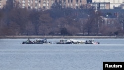 Trabalhadores de emergência recuperam destroços do rio Potomac na sequência da colisão do voo 5342 da American Eagle com um helicóptero Black Hawk, visto da Virgínia, EUA, 30 de janeiro de 2025