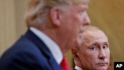 Presiden Rusia Vladimir Putin (kanan), melihat ke arah Presiden AS Donald Trump (kiri), saat Trump berbicara dalam konferensi pers gabungan di Istana Kepresidenan, di Helsinki, Finlandia, 16 Juli 2018.