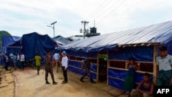 Para pejabat PBB dan polisi Bangladesh berjaga-jaga di depan tempat di mana PBB dan komisi pengungsi mewawancarai keluarga Rohingya di sebuah kamp pengungsi di Teknaf, 21 Agustus 2019. 