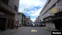 ARCHIVO - El cuerpo de un hombre asesinado por un pandillero yace cubierto en una calle de Tegucigalpa el 2 de noviembre de 2012. 