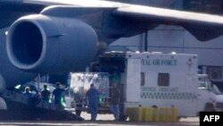 Medical workers transfer a female British health care worker from an aircraft into an ambulance at RAF Northolt, in west London, March 12, 2015. 