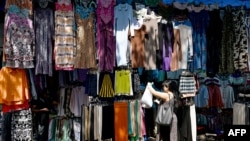 FILE - Customers browse secondhand clothes in a shop at a market in New Delhi, Sept. 28, 2024.