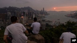 资料照片：来自中国大陆的游客在香港看日落。(2023年4月26日，美联社)