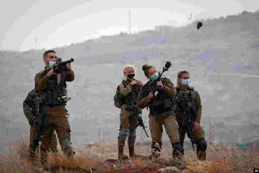 Israeli soldiers fire tear gas toward Palestinian demonstrators during a protest against the expansion of Israeli settlements near the West Bank village of Aqraba, north of Nablus.