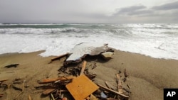 FILE - The wreckage from a capsized boat washes ashore at a beach near Cutro, southern Italy, Sunday, Feb. 26, 2023. 