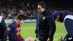 Lionel Messi, penyerang klub Barcelona asal Argentina, ditandu akibat cedera lutut ketika bertabrakan dengan kiper dalam pertandingan Liga Champions melawan klub Benfica (foto, 5/12/2012)..