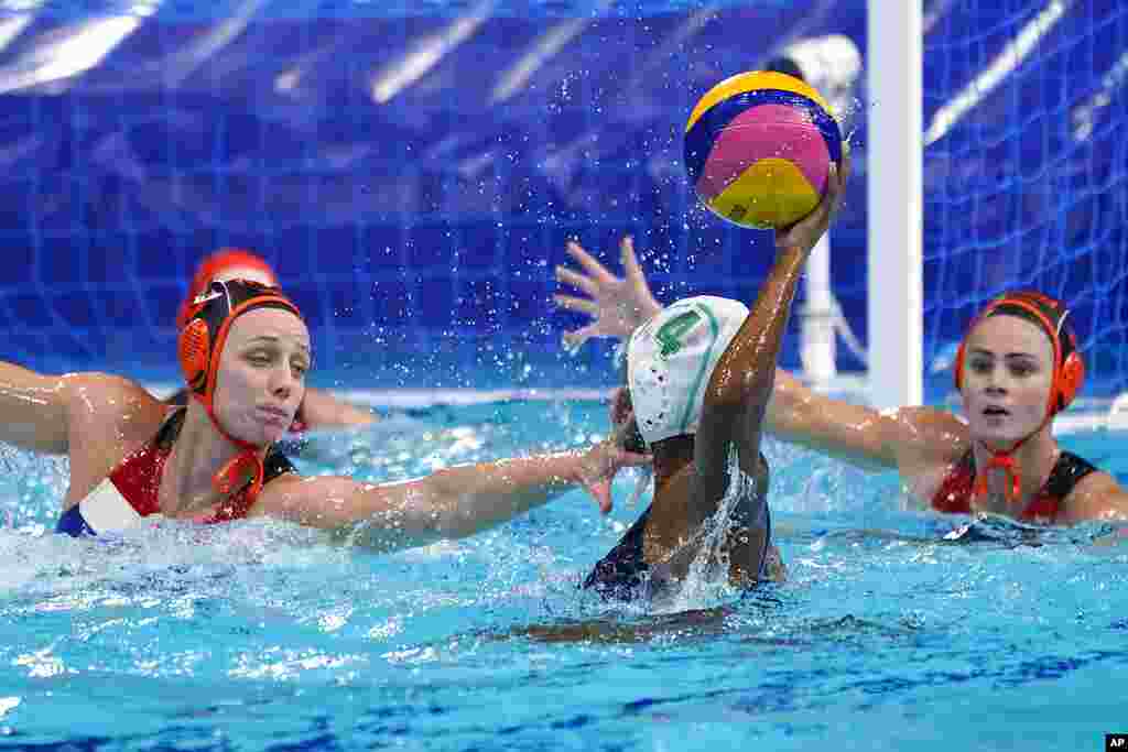 South Africa&#39;s Boati Motau (4) looks for a way past The Netherland&#39;s Maartje Keuning, left, and Brigitte Sleeking, right, during a preliminary round women&#39;s water polo match at the 2020 Summer Olympics, Friday, July 30, 2021, in Tokyo, Japan. (AP Photo/Mark Humphrey)