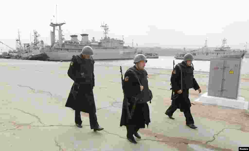 Russian sailors walk near the Ukrainian ship Slavutich in Sevastopol, March 20, 2014. 