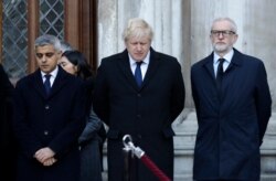 Britain's Prime Minister Boris Johnson, center, Labour Party leader Jeremy Corbyn, right, and Mayor of London Sadiq Khan take part in a vigil in memory of the attack victims, at Guildhall Yard in London, Dec. 2, 2019.