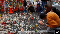 Para pelajar menyampaikan belasungkawa dengan menempatkan lilin dan bunga di depan masjid Al Noor di Christchurch, Selandia Baru. 