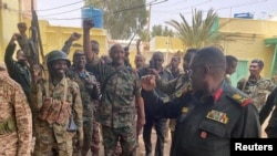 FILE: Sudan's General Abdel Fattah al-Burhan (center, fist raised) talks to troops on May 30, 2023. (Sudanese Armed Forces handout via Reuters.) 