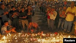 Migrants attend a candlelight ceremony at a railway station in memory of 71 refugees who died in a truck found in Austria, in Budapest, Hungary, Aug. 28, 2015.