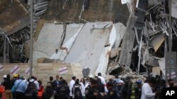 A crowd gathers around the partially collapsed Artz Pedregal shopping mall on the south side of Mexico City, July 12, 2018. 